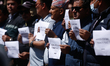 Activists from the Human Rights and Peace Society hold placards during a protest calling f...