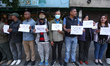 Activists from the Human Rights and Peace Society hold placards during a protest calling f...