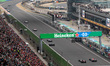 View of the main straight and grandstands filled with spectators as cars pass during the r...