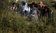 Palestinians pray at a cemetery on the grave of a relative during the first day of Eid al-...