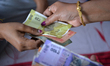 Indian women exchange Indian currencies in Siliguri, India, on March 20, 2026. The Indian...