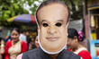 A supporter wears a cut-out face mask of Bharatiya Janata Party (BJP) candidate Himanta Bi...
