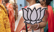 A supporter holds a Bharatiya Janata Party (BJP) lotus symbol placard during the nominatio...