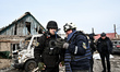 Police officers and rescuers work at the site where a Russian drone fell in a private sect...