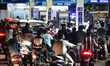 People queue to refuel their vehicles at a gas station in Hyderabad, Telangana, India, on...