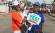 A woman holds a placard reading ''Yes We Can End Tuberculosis'' during an awareness walk i...