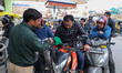 People queue to fill petrol in their two-wheelers at an Indian Oil Corporation fuel statio...