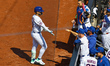 Bo Bichette #19 of the New York Mets is congratulated after a sacrifice fly during the fir...