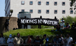 Masked demonstrators hold a banner that reads, ''No Kings, No Masters'' at a 'No Kings' de...