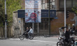 A motorcyclist rides beneath a billboard with anti-U.S. messaging in Tehran, Iran, on Marc...