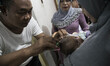  Grandfather of the baby shave the hair. Aqiqah tradtion held at a moeslim resident at Keb...