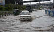 Vehicles try driving through the waterlogged exit street of Shahjalal International Airpor...