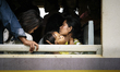 Cambodian migrants arrive by train at Aranyapathet Railway Station in Thailand before cros...