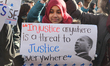 Muslim girl holds a sign (with a quote from Martin Luther King Jr.) during a massive prote...