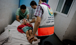 A young girl is being treated inside the emergency room in Shifa Hospital after a missile...