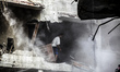 Palestinians inspect damage of an apartment building after it was hit by an Israeli missil...