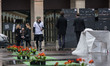 People walk past flowers laid by members of the group 'les Morts de la Rue' (The dead of t...