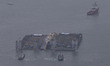Workers try to raise the sunken Sewol ferry, center, between two barges during the salvage...