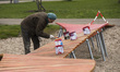 A worker paints a path in the water play area during a press preview of the IGA (Internati...