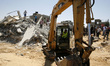 A Palestinian rescue workers search for victims in a building destroyed by an Israeli air...