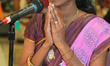 Tamil Hindu woman sings a devotional song honouring Lord Murugan during a festival at a Ta...