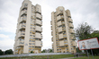An elderly woman walks past two tall apartment buildings in Brest, Belarus on 1 June, 2017...