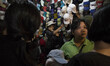 A girl try wearing a heat that she want to buy. After heavy fire hit senen market for clot...
