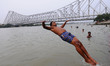A  man jump the Ganga River and Back Side Howrah Bridge during Hot Temperatures on June 06...