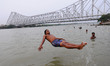 A  man jump the Ganga River and Back Side Howrah Bridge during Hot Temperatures on June 06...