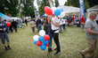 A young couple is seen holding balloons handed out by sponsors during an amsusement fare i...