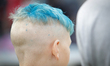 A young boy is seen with painted, purple hair during an amusement fare in Bydgoszcz, Polan...