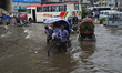 Citizens, Vehicles and Rickshaws try driving with passengers through the flooded streets o...