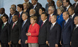 German Chancellor Angela Merkel (in red) poses for a family picture with other G20 summit...