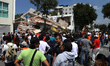People gather in front of a collapsed building after an earthquake in Mexico City, capital...