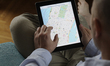 A man is seen looking at a map of New York City on an iPad running the Apple Maps applicat...