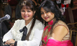 A fan poses with Bollywood playback singer Alisha Chinai (left) before her performance in...