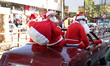 Men  dressed as a Santa Claus parade on a old car on the last day of 2017 in Gaza city, Pa...