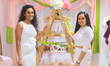 Women stand by their display selling traditional bridal items during a South Indian and Ta...