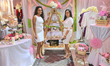 Women stand by their display selling traditional bridal items during a South Indian and Ta...