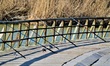 Fishing rods are placed on the pier next to an artificial lake during a warm day as the sp...