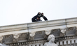 A U.S. Secret Service officer on the roof of the U.S. Capitol, prepares for the departure...