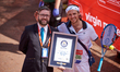 Runners dressed in fancy costumes receive a Guinness Record Certificate during the Virgin...