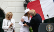 French First Lady Brigitte Macron (L), claps, as U.S. First Lady Melania Trump and U.S. Pr...