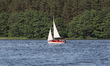 Small yacht sailing on the lake is seen in Przytarnia, Kashubia (Cassubia) region, Poland...