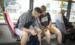 Two teenagers are seen using mobile devices in a public tram in Warsaw, Poland on June 12,...