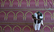 Nepalese Muslims hug each other after offering ritual morning prayers during celebration o...