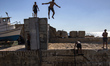 A teenager jumps into the water of the port at the ancient city of Jaffa near Tel Aviv, Is...