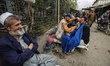 Barber shaves client on Bazaar street in Old city of Kabul, Afghanistan