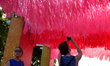Ribbons hang from a frame and move to the wind as community members celebrate summer at th...