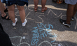 Demonstrators leave messages in chalk during the conclusion of an anti-gun violence march...